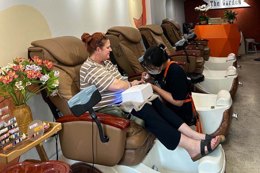 The employee is designing nails for customers at The Green Nail Spa