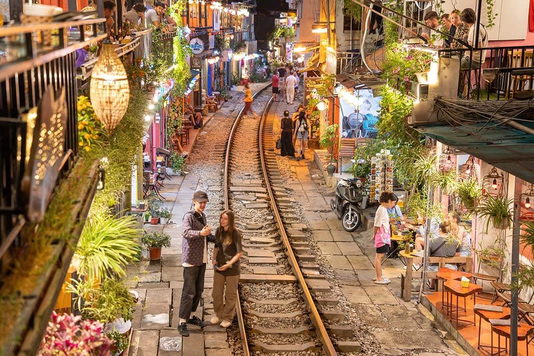 View of train passing through a narrow street of the Hanoi Old Quarter